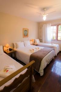 a hotel room with two beds and two lamps at Pousada Ouro de Minas in Tiradentes