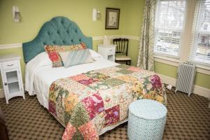 a bedroom with a bed with a quilt on it at Vandiver Inn in Havre de Grace