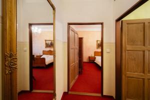 a hallway with a mirror and a room with a bedroom at Hotel Na Zámečku in Ústí nad Orlicí