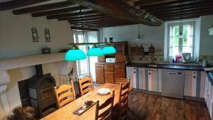 a kitchen with a wooden table and a fireplace at Gite Rouge and la Ferme Blanche in MÃ©nil-Vin