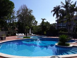 una piscina con agua azul en un resort en Chloé's Apartment, en Acireale
