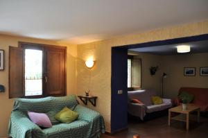 Can Simonet de Rocabruna في Rocabruna: غرفة معيشة مع أريكة وكرسي