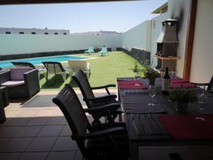 プラヤ・ブランカにあるVillaAntonia private huge heated pool and super fast wifiのパティオ(テーブル、椅子付)、プールが備わります。