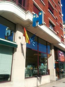 einen Laden vor dem Fenster mit einer Flagge in der Unterkunft Hotel Carbayon in Oviedo