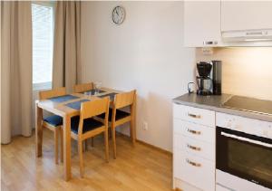a kitchen with a table and chairs in a kitchen at Cozy Central Studio Tampere in Tampere