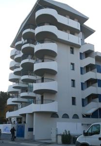 un edificio blanco con balcones en un lateral en Apart Hotel Atlantic, en Grado