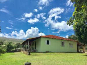 a small house in a field with a blue sky at Sítio Felicidade-Capitolio-Furnas-MG in Elisiário Lemos