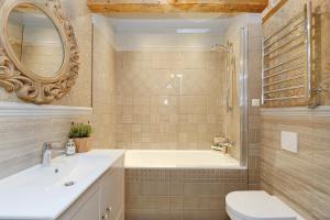 une salle de bain avec une baignoire, un lavabo et des toilettes dans l'établissement Dzirnavu Residense, à Riga