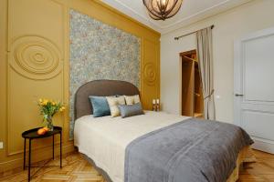 1 dormitorio con 1 cama y un jarrón de flores sobre una mesa en Dzirnavu Residense en Riga