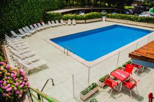 a swimming pool with chairs and a bunch ofituresitures at Hotel las Dunas in Noja