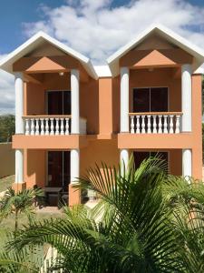 dom z balkonem i palmami w obiekcie El Currican Juan Dolio w mieście Juan Dolio