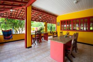 a dining room with yellow walls and a table and chairs at Pousada dos Gravatais in Marataizes
