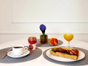 a table with a sandwich and a cup of coffee at Chopin Apartments - Eco in Warsaw