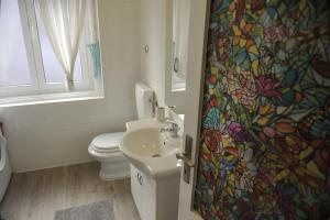 een badkamer met een wastafel, een toilet en een douchegordijn bij Rijeka center- Apartment Flumen in Rijeka