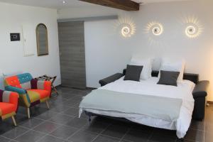 una camera da letto con un letto grande e due sedie di La Petite Ferme du Marais a Saint-Germain-du-Bois Altre 71 foto