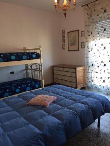 1 dormitorio con 1 cama azul y literas en Casa Donatella, en Marina di Massa