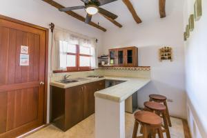 a kitchen with a sink and a counter with two stools at Villas Margaritas Holbox in Holbox Island