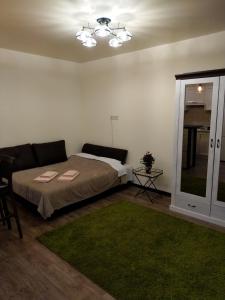 a bedroom with a bed and a couch and a window at АpartmentAnna in Odesa