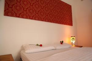 a bedroom with a bed with white sheets and a red painting at Casa Mimi in Santa Flavia