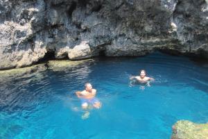two men are swimming in a blue cave at Lithoktisto in Limnionas