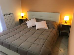 a bedroom with a large bed with two lamps at Cà Giorg in Fanano
