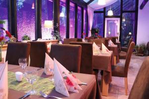 a restaurant with tables and chairs with purple lights at Hotel Feldmaus in Olzheim
