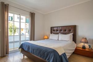 a bedroom with a bed and a large window at Old Town House Madeira in Funchal
