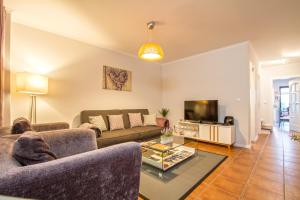 a living room with a couch and a tv at Old Town House Madeira in Funchal