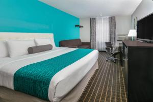 a hotel room with a large bed and a television at Howard Johnson by Wyndham Near Schlitterbahn in New Braunfels