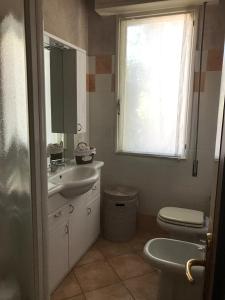 ein Bad mit einem Waschbecken, einem WC und einem Fenster in der Unterkunft Holiday House Ambra in San Felice del Benaco