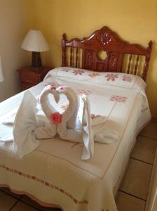 a bed with two swans made to look like hearts at HOTEL CAMELINAS AREA BLANCA in Pátzcuaro