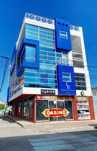 a tall blue building with a store in front of it at Hostal Central Beach in San Andrés