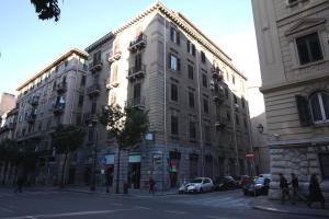 un gran edificio en una calle de la ciudad con coches aparcados delante en Oasi del Turista, en Palermo