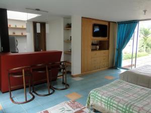 a bedroom with a bed and a desk in a room at Hotel Familiar El Remanso Del Agua in Guatapé