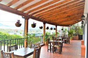 a patio with tables and chairs and potted plants at Balcones de la Casona in Guatapé