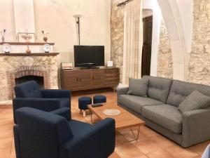 een woonkamer met 2 banken en een tv bij Komi Lofou House by TrulyCyprus in Lofou