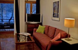 ein Wohnzimmer mit einem Sofa und einem TV in der Unterkunft Lake view apartment in Ioannina