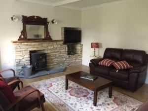a living room with a couch and a fireplace at Gortamullen House, Kenmare in Kenmare