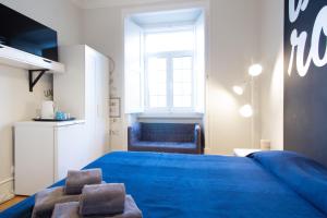 リスボンにあるLxRoller Premium Guesthouseのベッドルーム(青いベッド1台、青い椅子付)