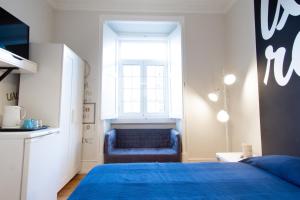 リスボンにあるLxRoller Premium Guesthouseのベッドルーム(青いベッド1台、窓付)