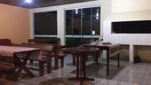 a dining room with tables and chairs and windows at Hotel Solar Flores in Alegrete