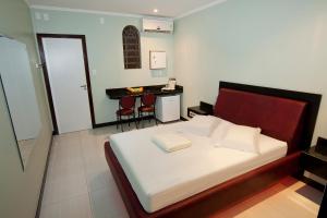 a bedroom with a bed and a table and chairs at MOTEL 3 PEIXINHOS (Adults Only) in Blumenau