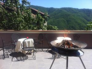 a fire pit on a patio with a table and chairs at Castel Di Gufi in Comano