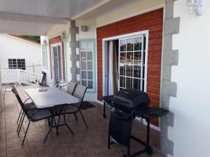 a patio with a grill and a table and chairs at Bonne View Villa in Rodney Bay Village