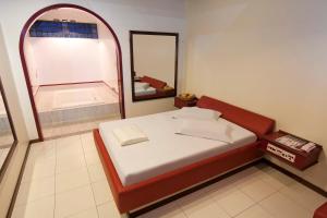 a small bedroom with a bed and a mirror at MOTEL 3 PEIXINHOS (Adults Only) in Blumenau