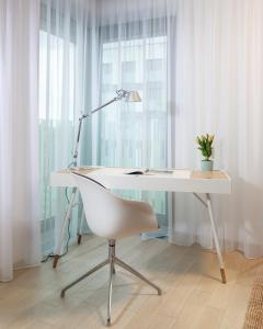 escritorio blanco con lámpara y silla blanca en Luxurious Apartments at Žižkov, en Praga