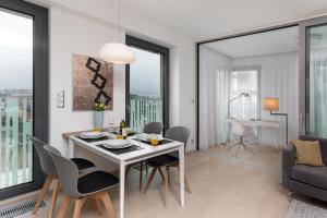 comedor y sala de estar con mesa blanca y sillas en Luxurious Apartments at Žižkov, en Praga