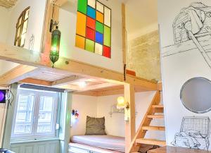 a loft bed in a tiny room with a window at Lavender Circus Hand Drawn Apartments in Budapest