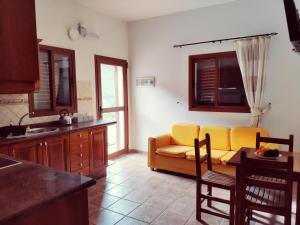a living room with a yellow couch and a kitchen at Casas Blancas - Suite 3 in Tasartico