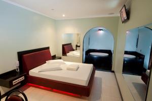 ein Schlafzimmer mit einem Bett und einem großen Spiegel in der Unterkunft MOTEL 3 PEIXINHOS (Adults Only) in Blumenau